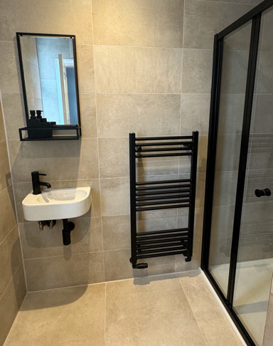 Shower room with shower, sink and vertical towel radiator
